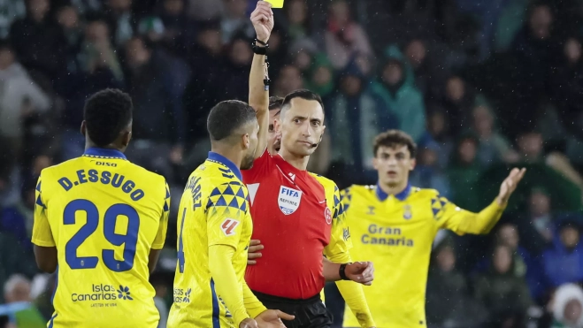 El defensa de la UD Las Palmas José Alejandro Suárez (2i) recibe tarjeta amarilla durante el partido de LaLiga que Real Betis y UD Las Palmas disputan hoy domingo en el Benito Villamarín, en Sevilla. EFE/José Manuel Vidal