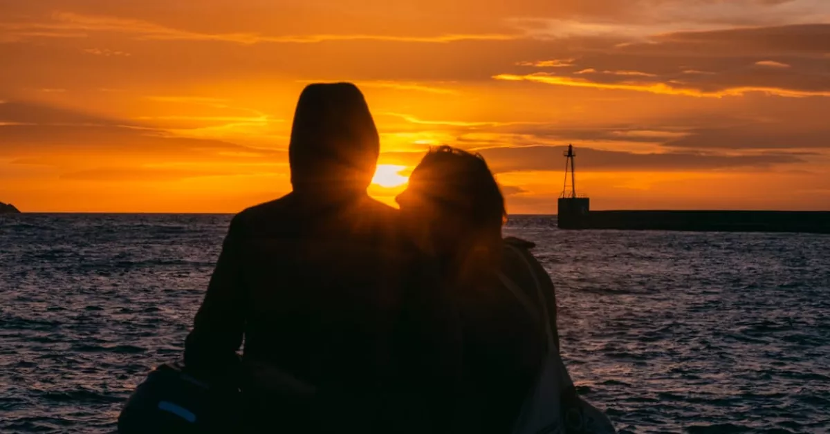 Dos personas miran con añoranza el atardecer / PEXELS