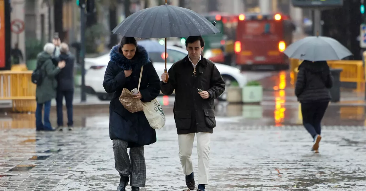 Imagen de dos personas caminando con lluvia / EFE