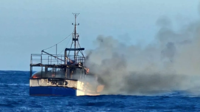 El pesquero 'Montes y Sabino', envuelto en llamas, frente a Taliarte, en Telde, poco antes de hundirse. / AH