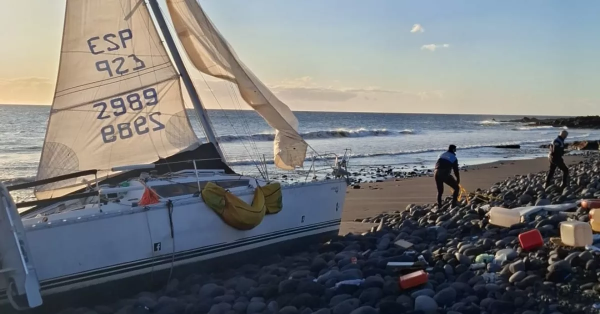 Un velero que quedó encallado en la playa de El Socorro de Güímar, con agentes de la Policía Local al rededor./ CEDIDA
