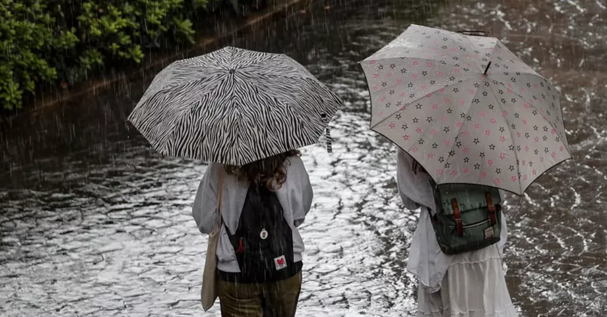 Imagen de dos personas paseando en medio de una borrasca / EFE