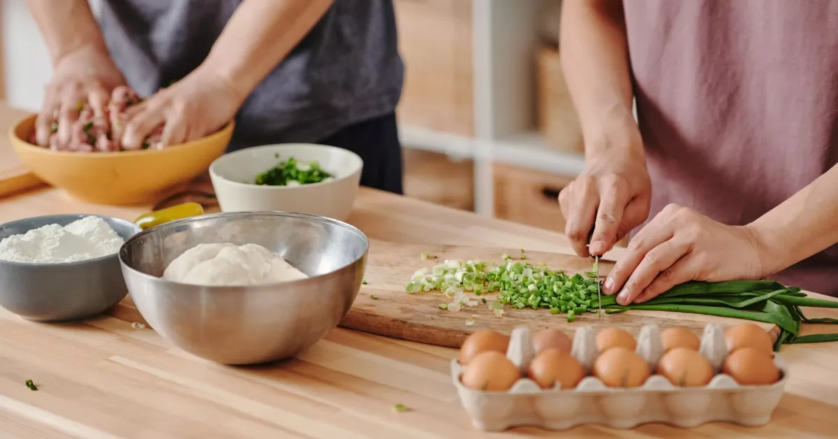 Imagen de dos personas cocinando un plato típico / PEXELS