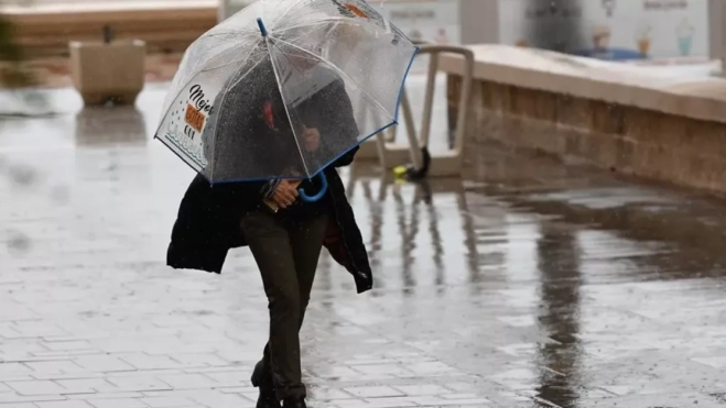 Imagen de una persona caminando bajo la lluvia en una borrasca / EFE Imagen de una persona caminando bajo la lluvia en una borrasca / EFE