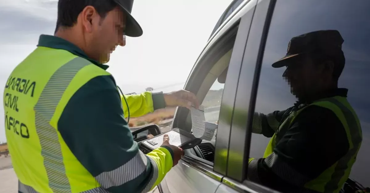 Un agente de la Guardia Civil de Tráfico entrega una notificación durante un control de velocidad / EFE