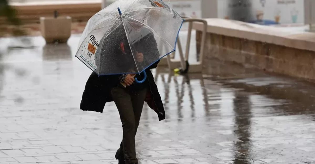 Imagen de una persona debajo de la lluvia en una borrasca / EFE