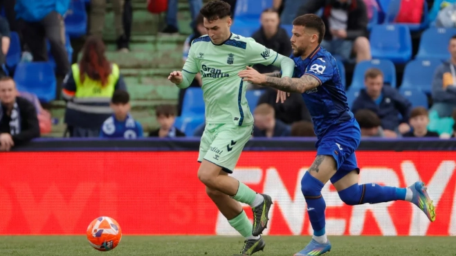 El defensa del Getafe Juan Bernat (d) disputa un balón con el centrocampista de Las Palmas Stefan Bajčetić (i) / EFE