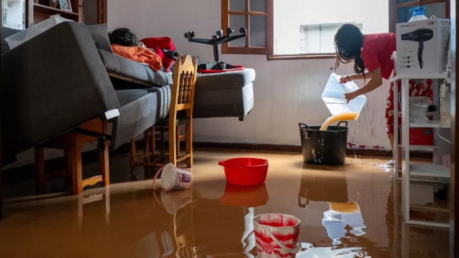 Una persona achica agua en su domicilio de Arrecife (Lanzarote) / EFE - ADRIEL PERDOMO