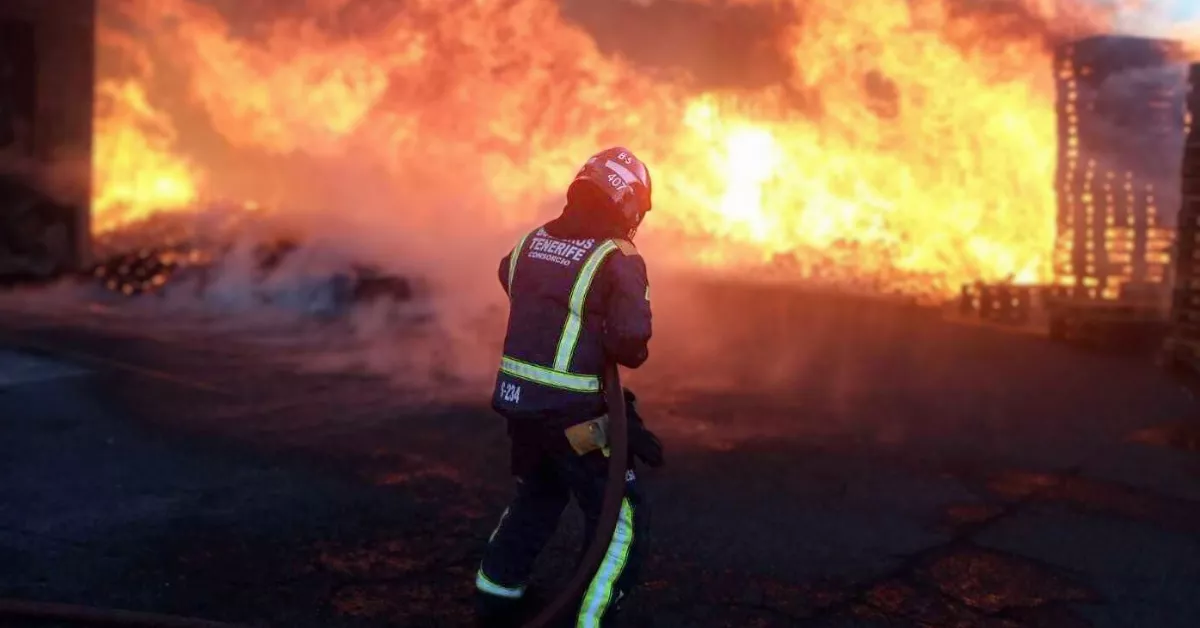 Un bombero de Tenerife apagando un incendio en una nave industrial del polígono de Güímar./ CABILDO TENERIFE