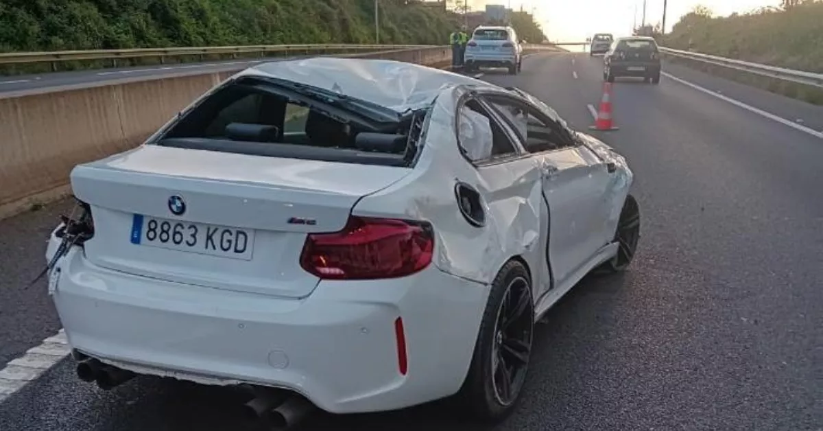 BMW cuyo conductor causó de forma temeraria un grave accidente en la TF-5 el Jueves Santo. Al fondo, un Porsche Cayenne blanco presuntamente del padre del conductor, que conversa con dos agentes de la Guardia Civil./ RRSS