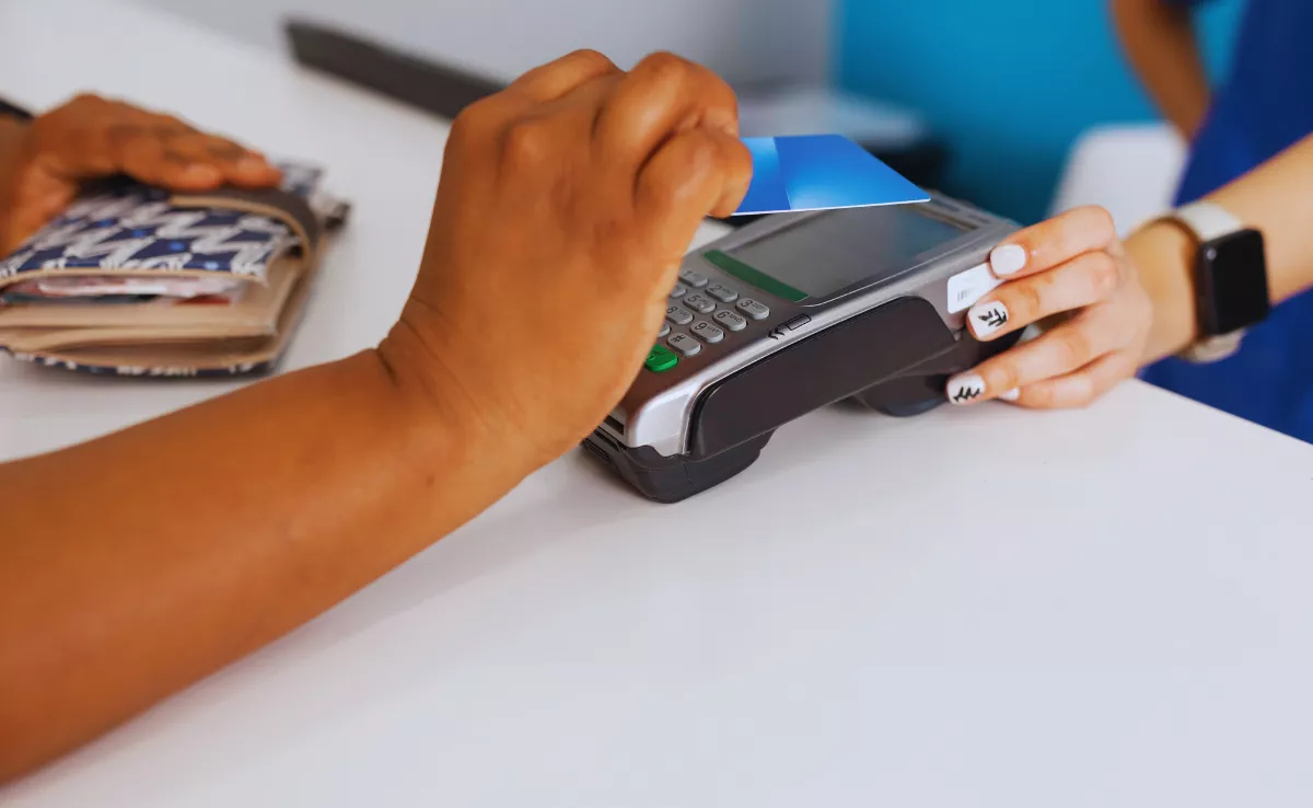 Imagen de una persona pagando con tarjeta en negocios / CANVA