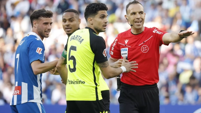 El árbitro del partido Guillermo Cuadra Fernández (d) conversa con Bartra del Betis, durante el partido de la jornada 34 de LaLiga EA Sports que RCD Espanyol y Real Betis Balompié disputan este domingo en el RCDE Stadium de Cornellá de Llobregat (Barcelona). / ANDREU DALMAU-EFE El árbitro del partido Guillermo Cuadra Fernández (d) conversa con Bartra del Betis, durante el partido de la jornada 34 de LaLiga EA Sports que RCD Espanyol y Real Betis Balompié disputan este domingo en el RCDE Stadium de Cornellá de Llobregat (Barcelona). / ANDREU DALMAU-EFE