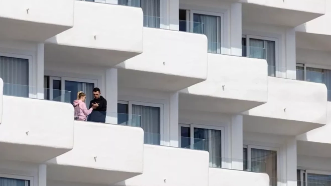 Una pareja de turistas en la terraza de una de las habitaciones de un hotel / EFE