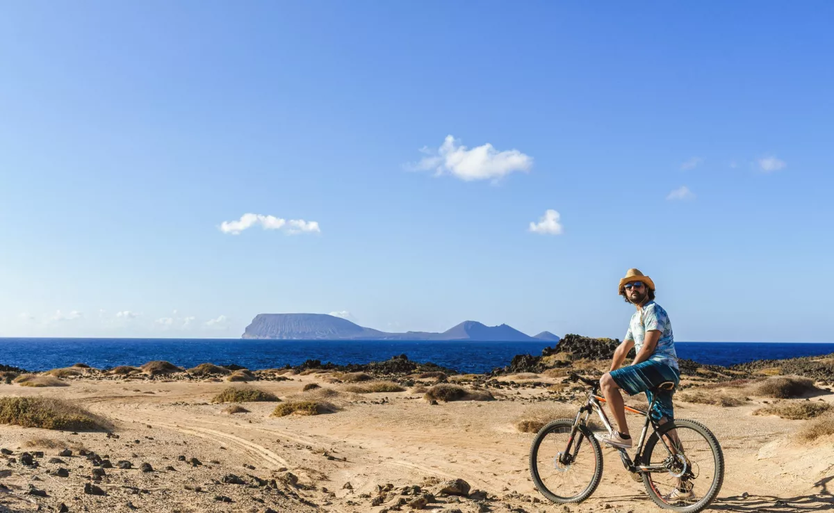 Imagen de una persona recorriendo La Graciosa (Canarias) en bicicleta / VISIT LA GRACIOSA
