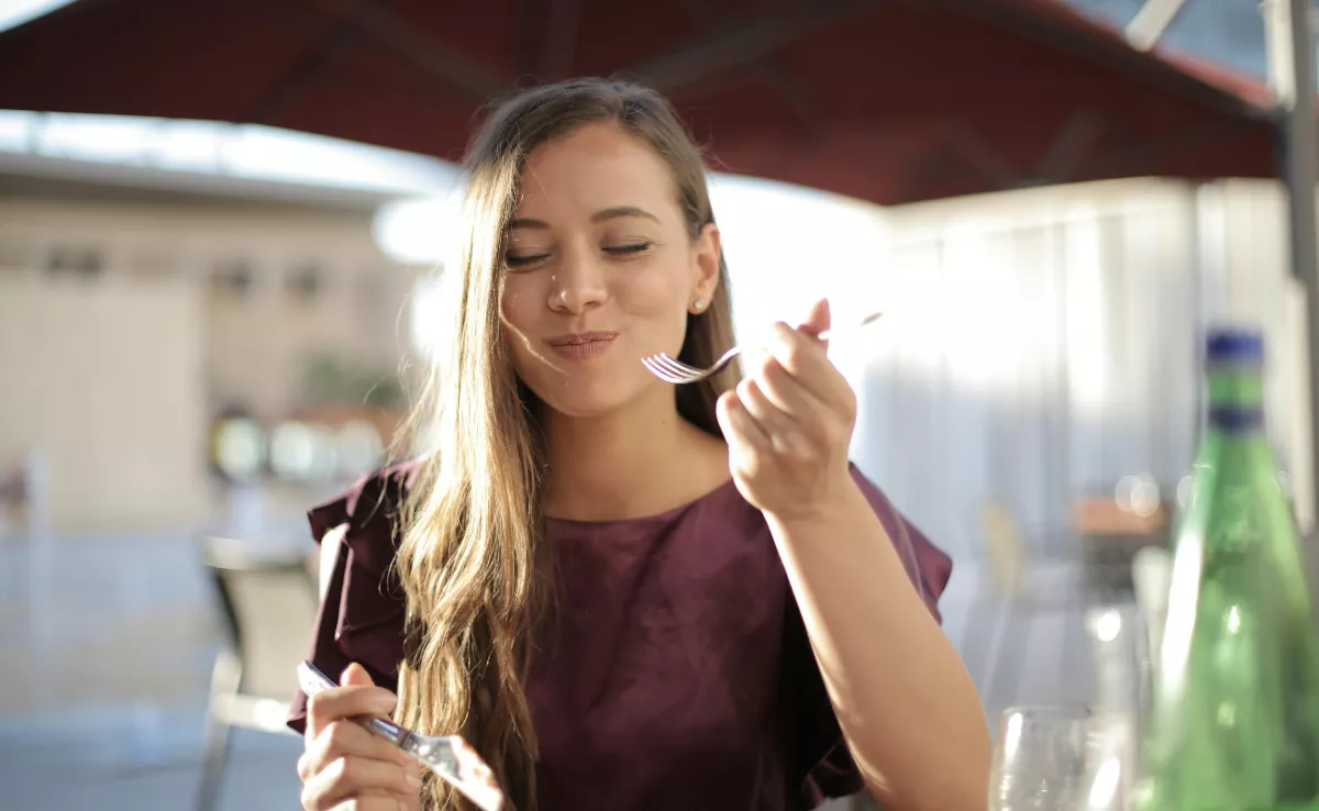 Imagen de una mujer comiendo  PEXELS