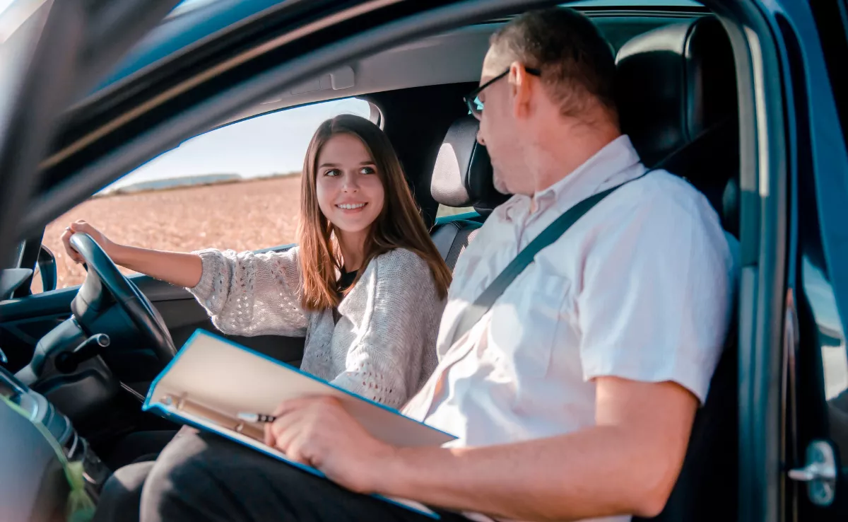Imagen de una chica y un examinador durante el examen del carné de conducir / CANVA