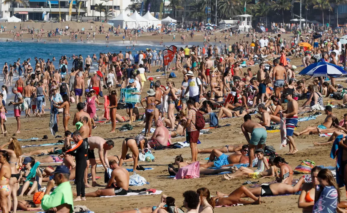 una gran cantidad de personas disfrutan en una playa turística canaria|EFE