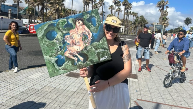 Una joven posa junto a su pancarta en Las Palmas de Gran Canaria / ATLÁNTICO HOY - MARCOS MORENO