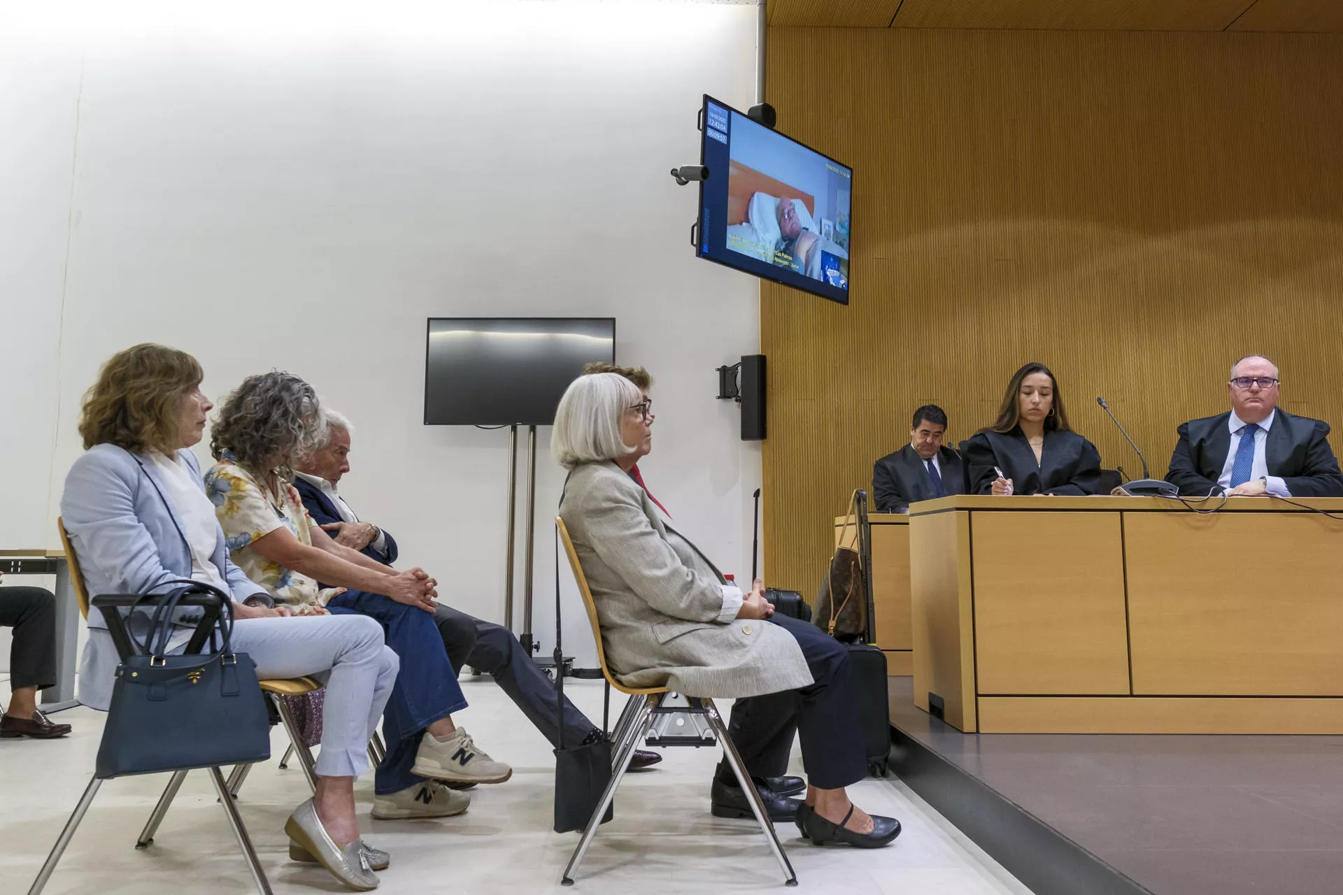 Kokorev acepta 2 años y 3 meses de cárcel y una multa de 20 millones por blanqueo de capitales. En la imagen, el emoresario ruso aparece en la pantalla (y justo debajo, su mujer). / ÁNGEL MEDINA G.-EFE