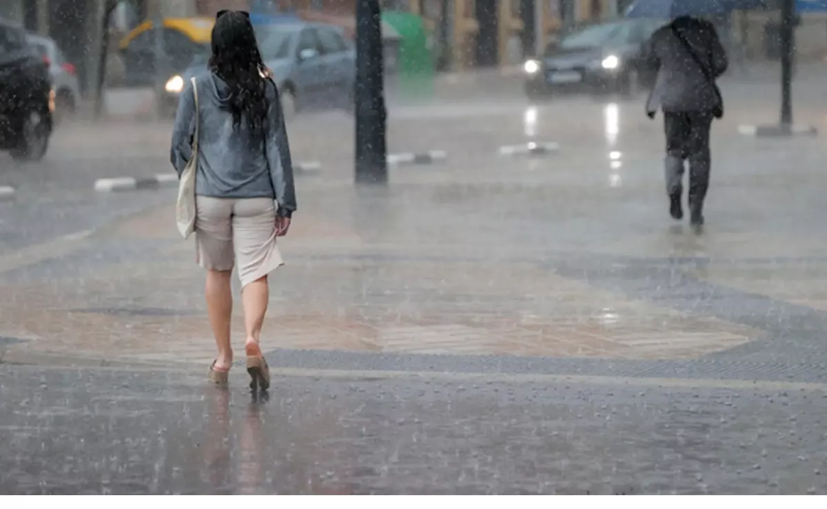 Imagen de una mujer caminando bajo la lluvia / EFE