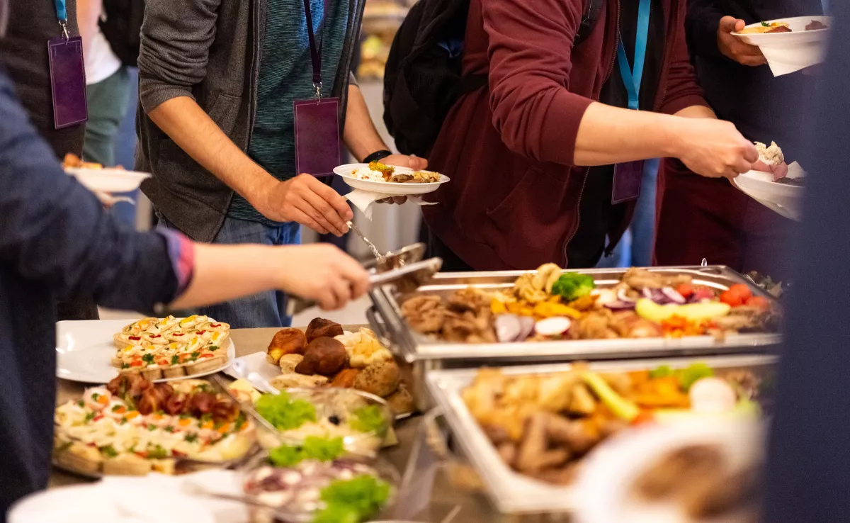 Un grupo de personas comiendo en un buffet / PEXELS