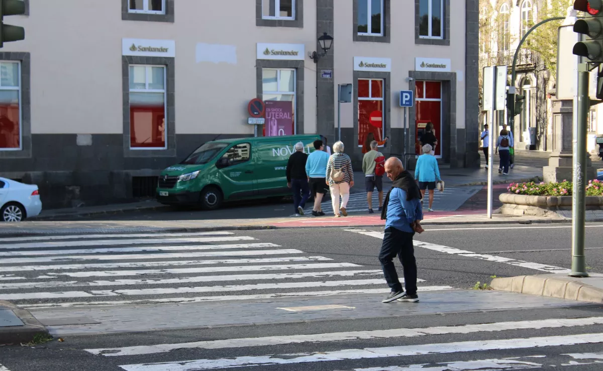Un señor lee uno de los carteles de la campaña contra el Paseo Guiniguada mientras cruza el barranco de Guiniguada / DESCUBRE GUINIGUADA