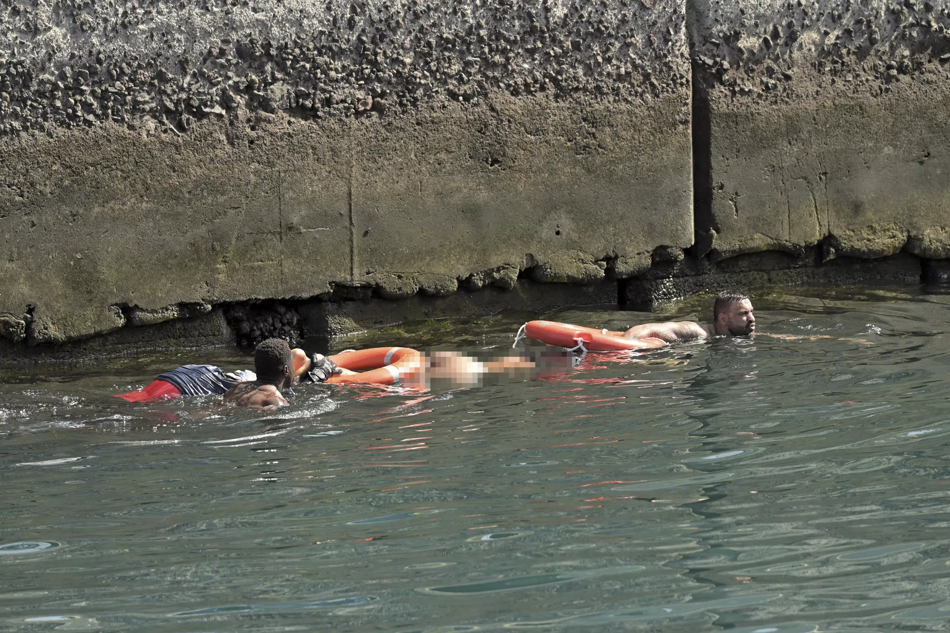 Un vecino de La restinga recupera dos cuerpos y ayuda a otro migrante a salir del agua en La restinga tras el vuelco de un cayuco el pasado miércoles. / GELMERT FINOL-EFE