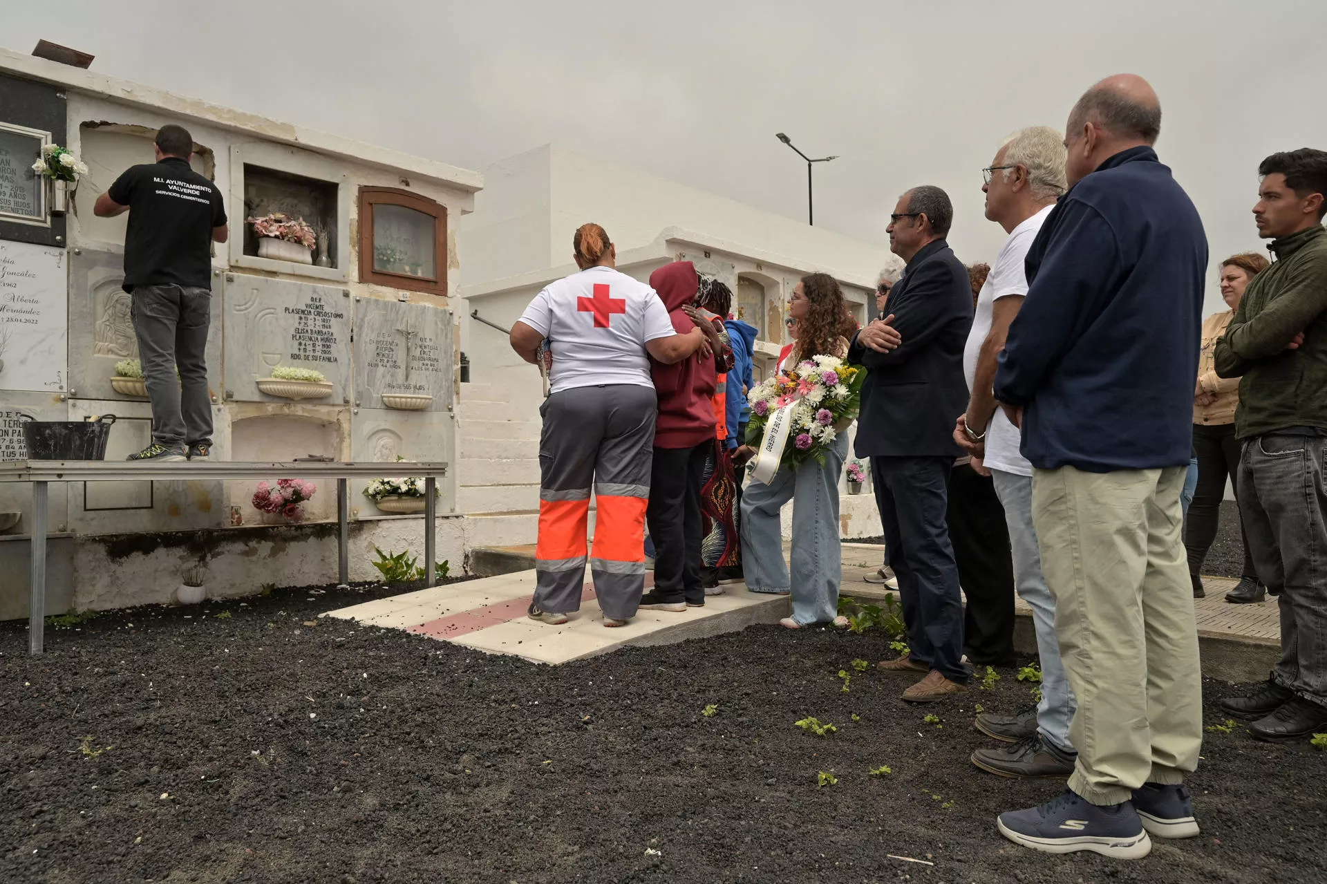  Una voluntaria de Cruz Roja consuela a una mujer durante el entierro en Valverde. / EFE - GELMERT FINOL