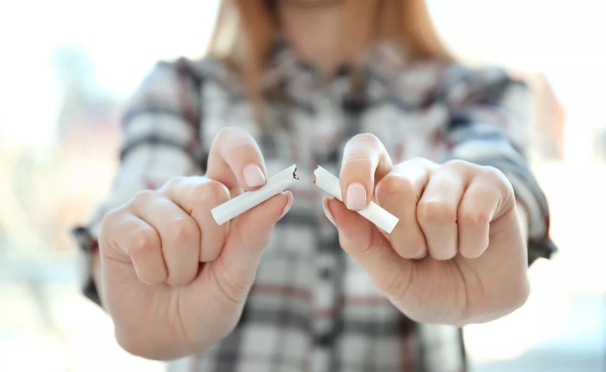 Una mujer parte un cigarro. La demanda de medicamentos para dejar de fumar cae un 12% en las farmacias./ SERVIMEDIA