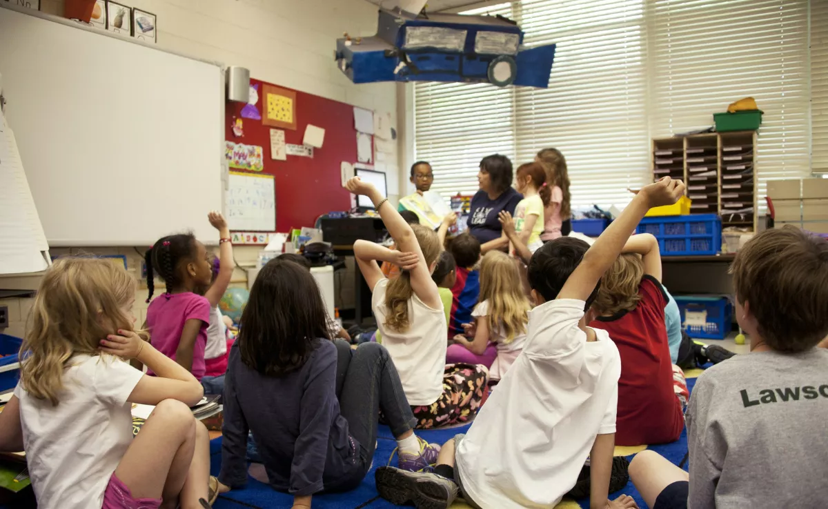 Imagen de niños en un colegio con una docente / UNSPLASH 