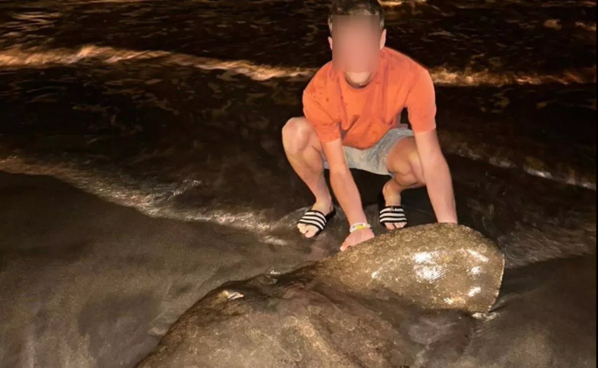 Un turista neerlandés posa con un ejemplar de mantelina (Gymnura altavela), especie en peligro de extinción / AH