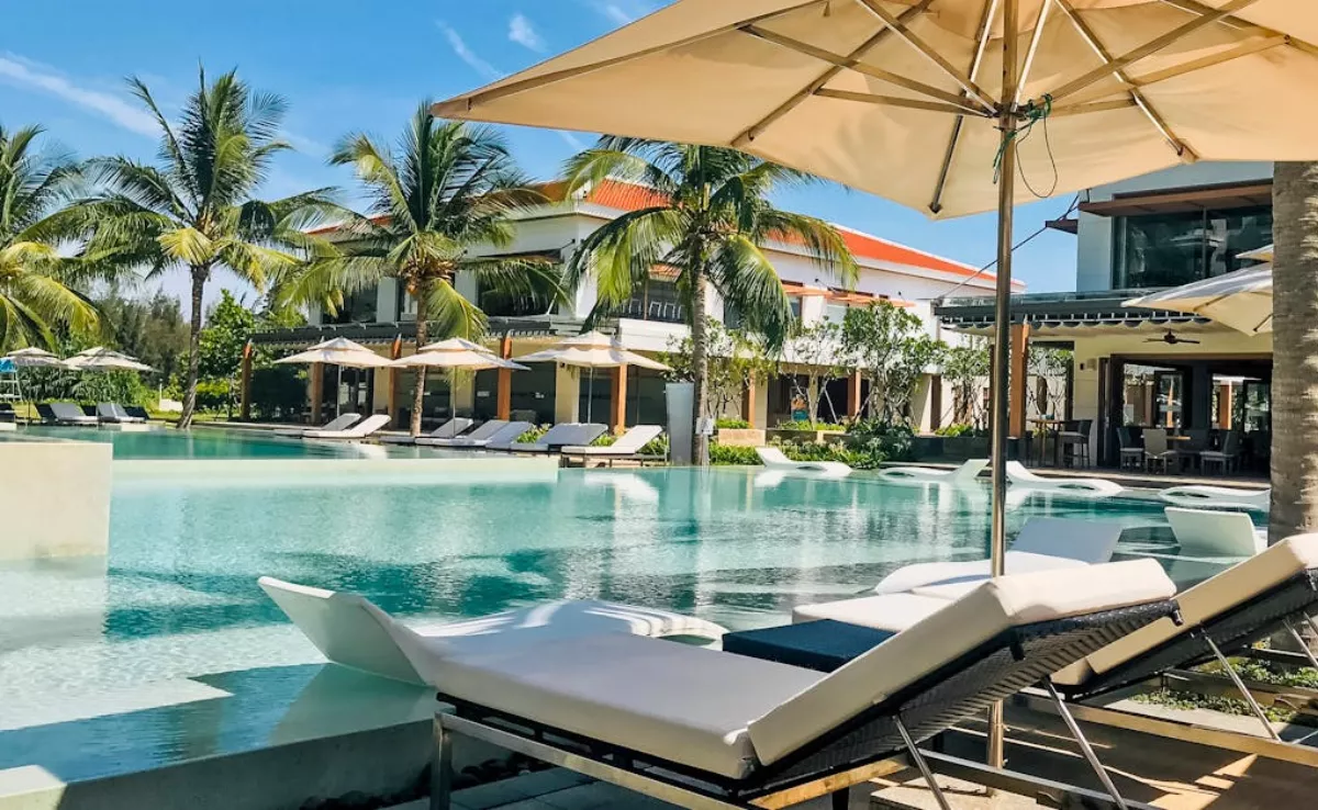 Imagen genérica de una piscina con hamacas y sombrillas / PEXELS