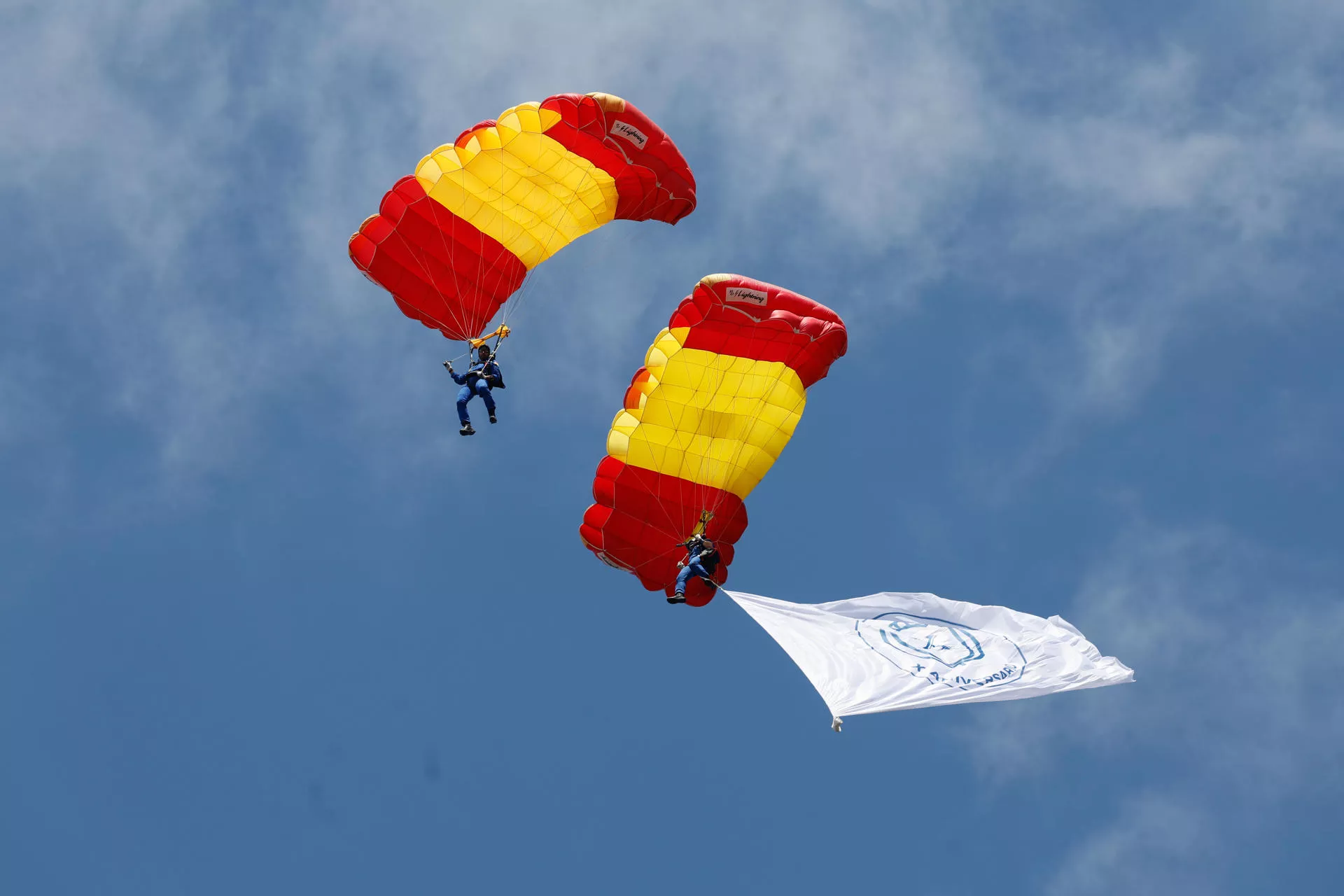 Un paracaidista desciende con la bandera de España. Un paracaidista desciende con la bandera de España.