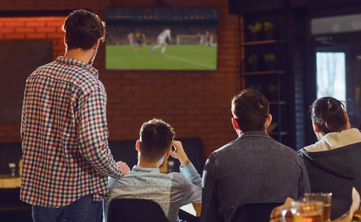 Un grupo de amigos ve un partido de fútbol / AH