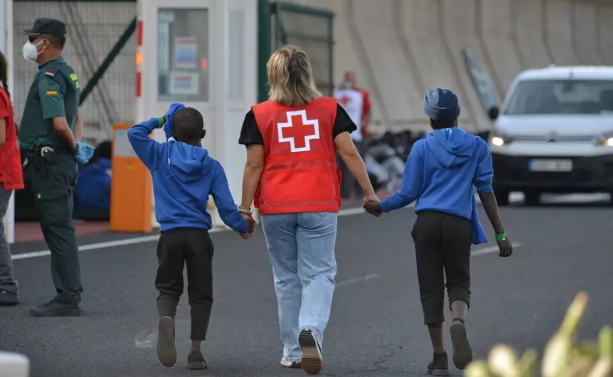 Imagen de una trabajadora de Cruz Roja con dos menores en El Hierro / EFE - GELMERT FINOL