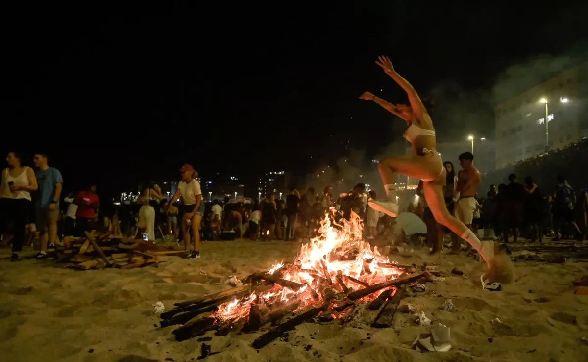 Imagen de una mujer saltando por encima de una hoguera de San Juan / EFE