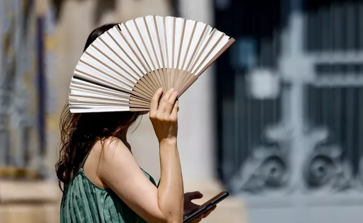 Imagen de una mujer tapándose del sol y altas temperaturas / EFE