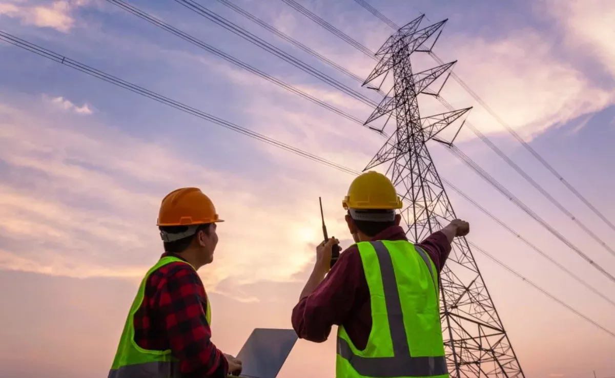 Dos trabajadores junto a una torre de alta tensión./ VFM