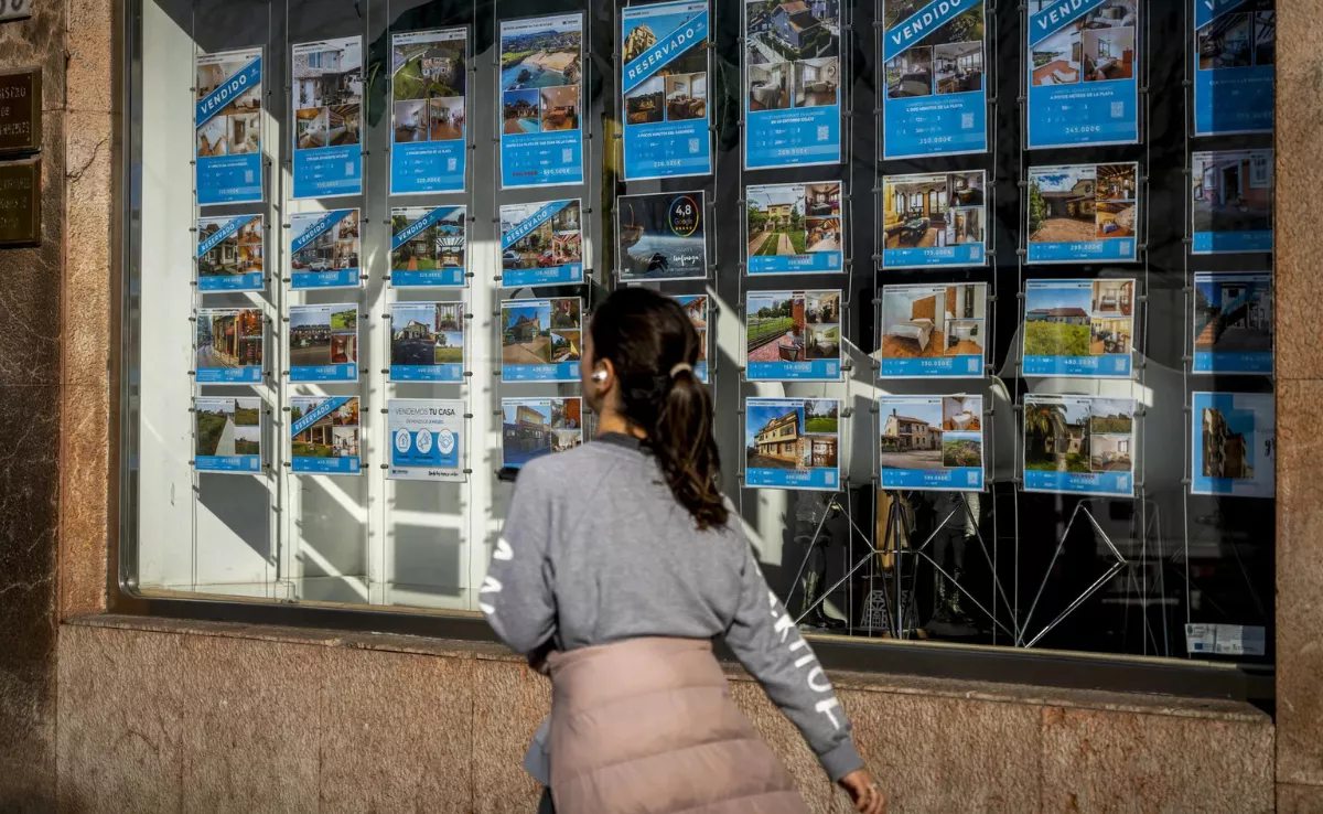 Imagen de una persona frente a un tablón de anuncios de viviendas en venta / ARCHIVO