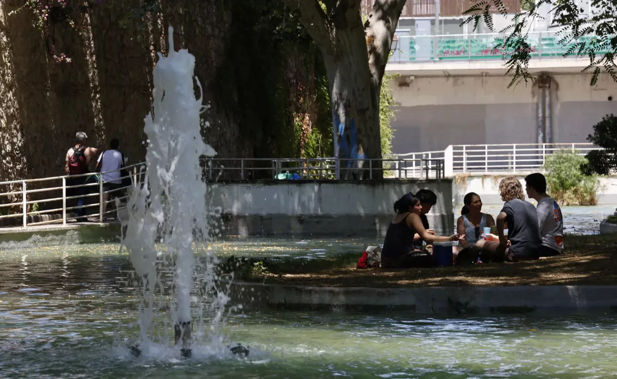 Un grupo de personas se refugia del calor en un parque / EFE