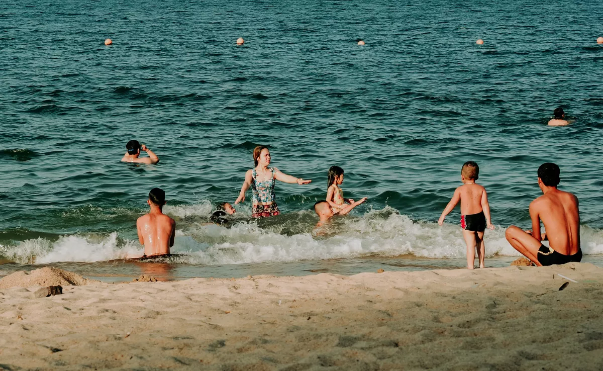 Un grupo de personas en la playa / CANVA