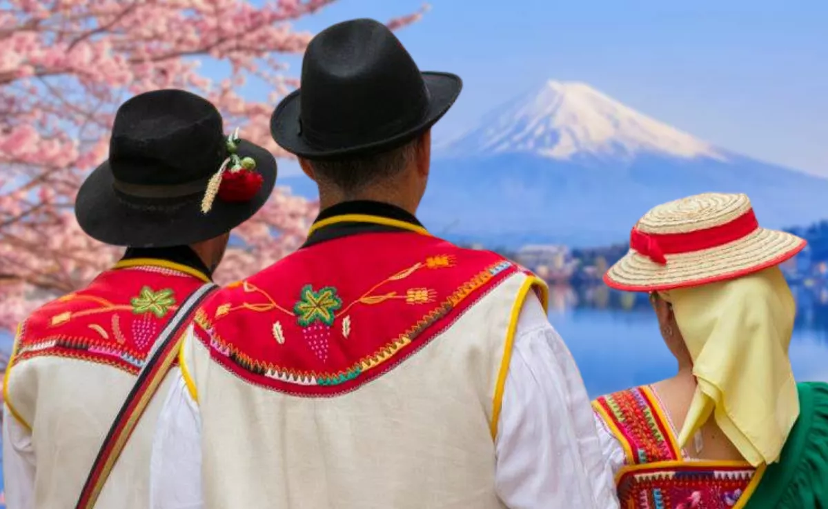 Un grupo de canarios vestidos con trajes tradicionales miran el monte Fuji en Japón./ MONTAJE AH