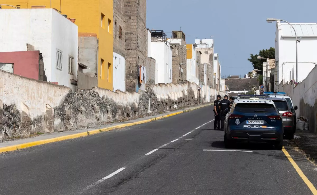  Esa Canarias que no quieren ver los del tópico y el jardín sideral . En la imagen, agentes policiales delante del inmueble donde quemaron a la menor, en el barrio de La Isleta. EFE / Quique Curbelo