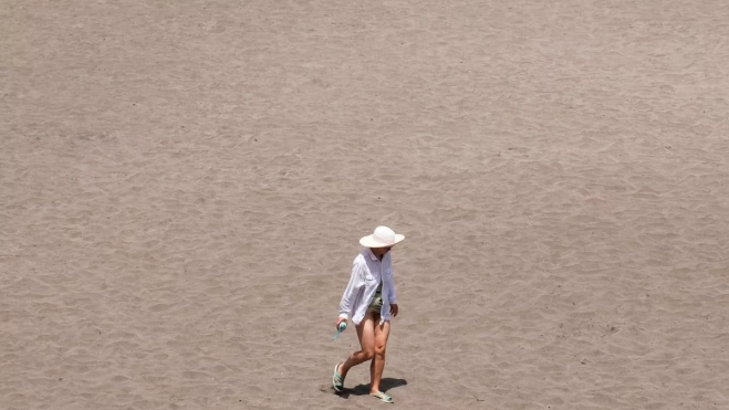 Un mujer se protege del sol en la costa de La Laguna, en Tenerife. Canarias está en alerta por altas temperaturas. EFE / Alberto Valdés