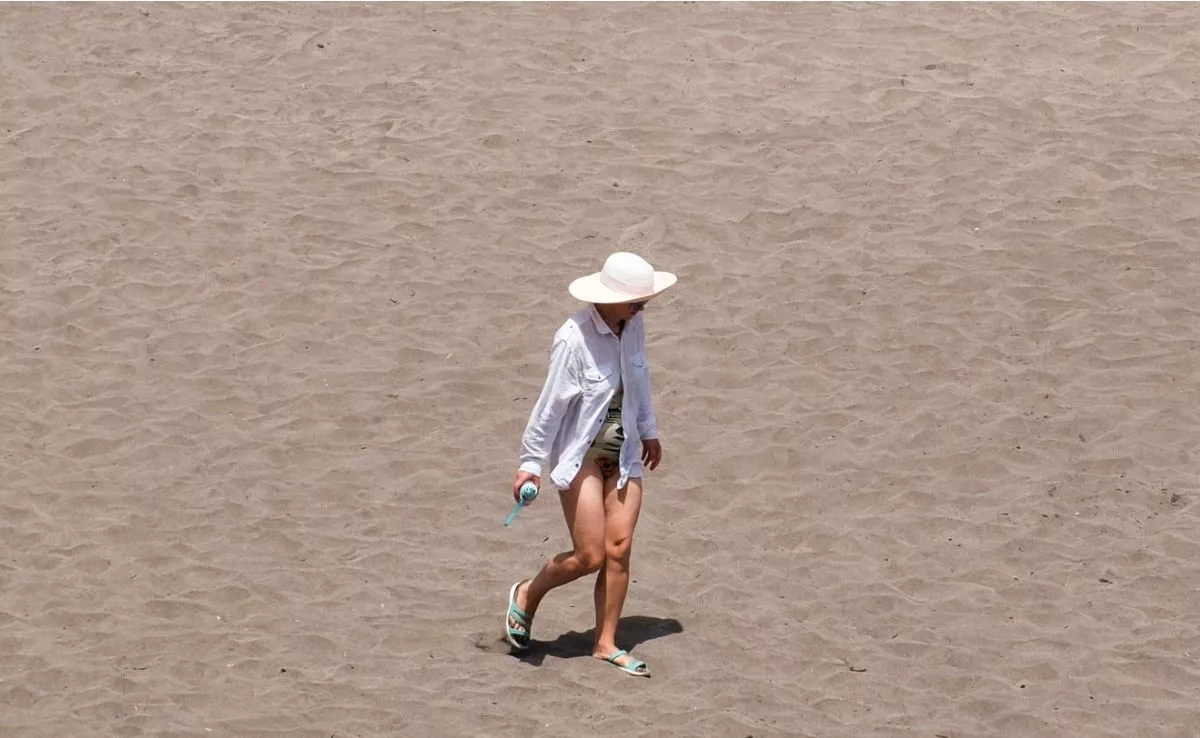 Un mujer se protege del sol en la costa de La Laguna, en Tenerife. Canarias está en alerta por altas temperaturas. EFE / Alberto Valdés