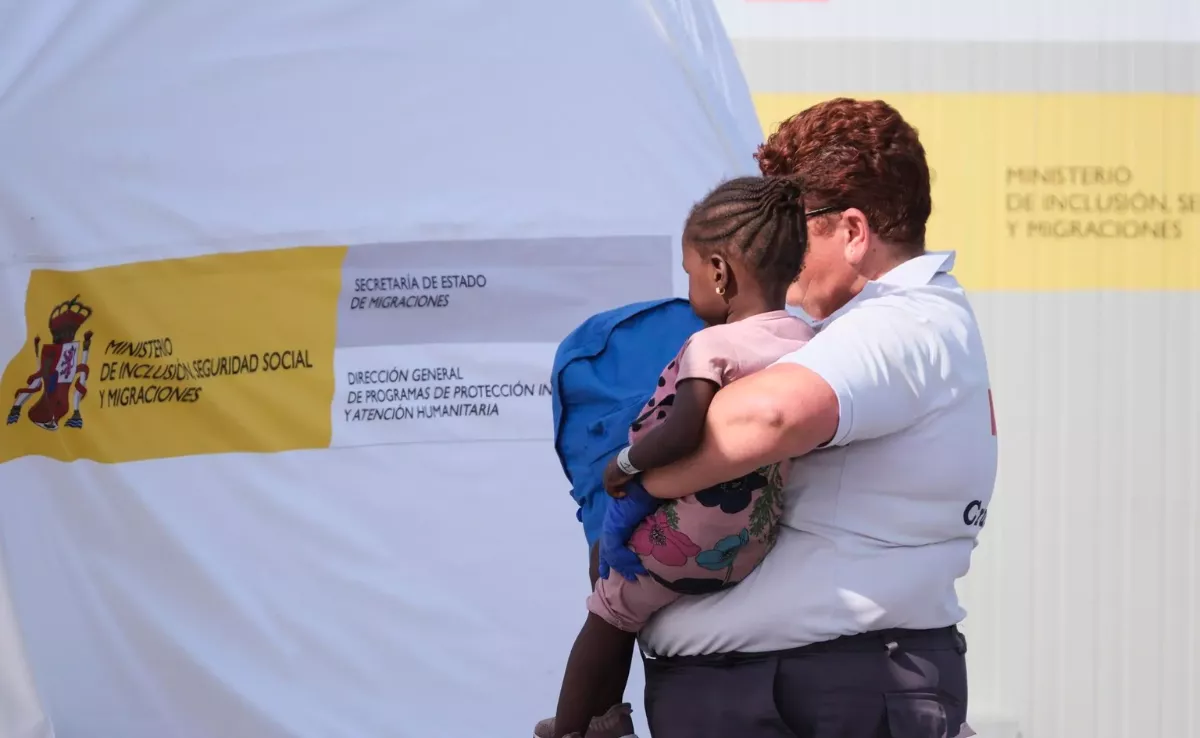 Una trabajadora de Cruz Roja con una menor migrante / EFE