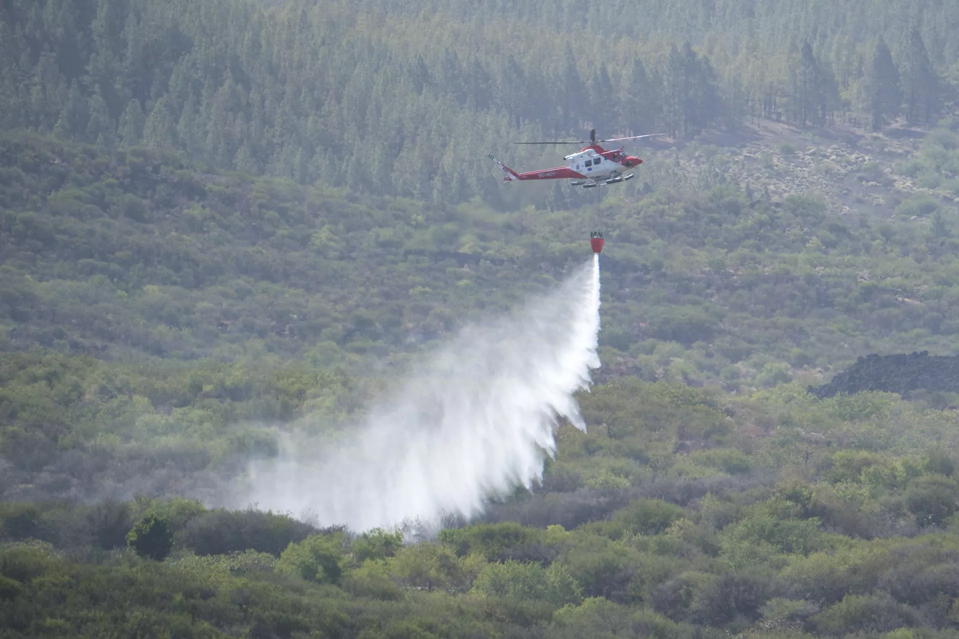 Un helicóptero del Gobierno de Canarias descarga agua sobre la zona afectada por el incendio. / EFE - ALBERTO VALDÉS