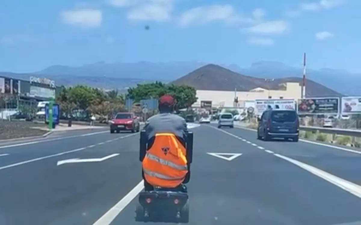 Un hombre en silla de ruedas cruza la TF-65 en plena hora punta en Las Chafiras. / AH