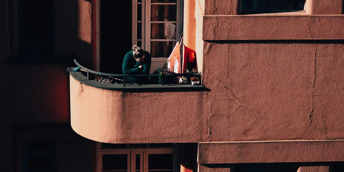 Imagen de una persona asomada en un balcón / PEXELS