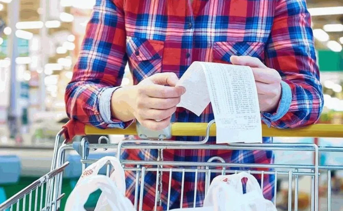 Un hombre controla su economía y comprueba el recibo de su compra|ANALITIK